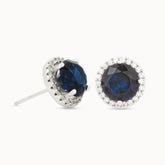 Product close up of Azuline Halo platinum-plated stud earrings with a dark blue centerpiece and radiant halo accents