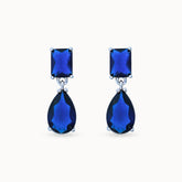 Product Close up of Azura Glow Drops, platinum-plated earrings with dark blue sapphire-like stones for an elegant, minimalistic look