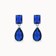 Product Close up of Azura Glow Drops, platinum-plated earrings with dark blue sapphire-like stones for an elegant, minimalistic look