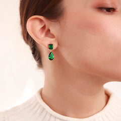 Close-up of Emerald Essence Drop Earrings showing rich green stone and gold finish
