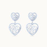 Product Close up of Elegant platinum-plated double-heart earrings with an intricate rose pattern inside, perfect for any occasion