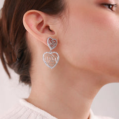 Close up of Elegant platinum-plated double-heart earrings with an intricate rose pattern inside, perfect for any occasion