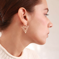 Modern downward-facing triangular hoops plated in 18k gold, named Golden Vertex. Lightweight and hypoallergenic, perfect for a bold yet minimalist look