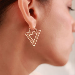 Close up of Modern downward-facing triangular hoops plated in 18k gold, named Golden Vertex. Lightweight and hypoallergenic, perfect for a bold yet minimalist look